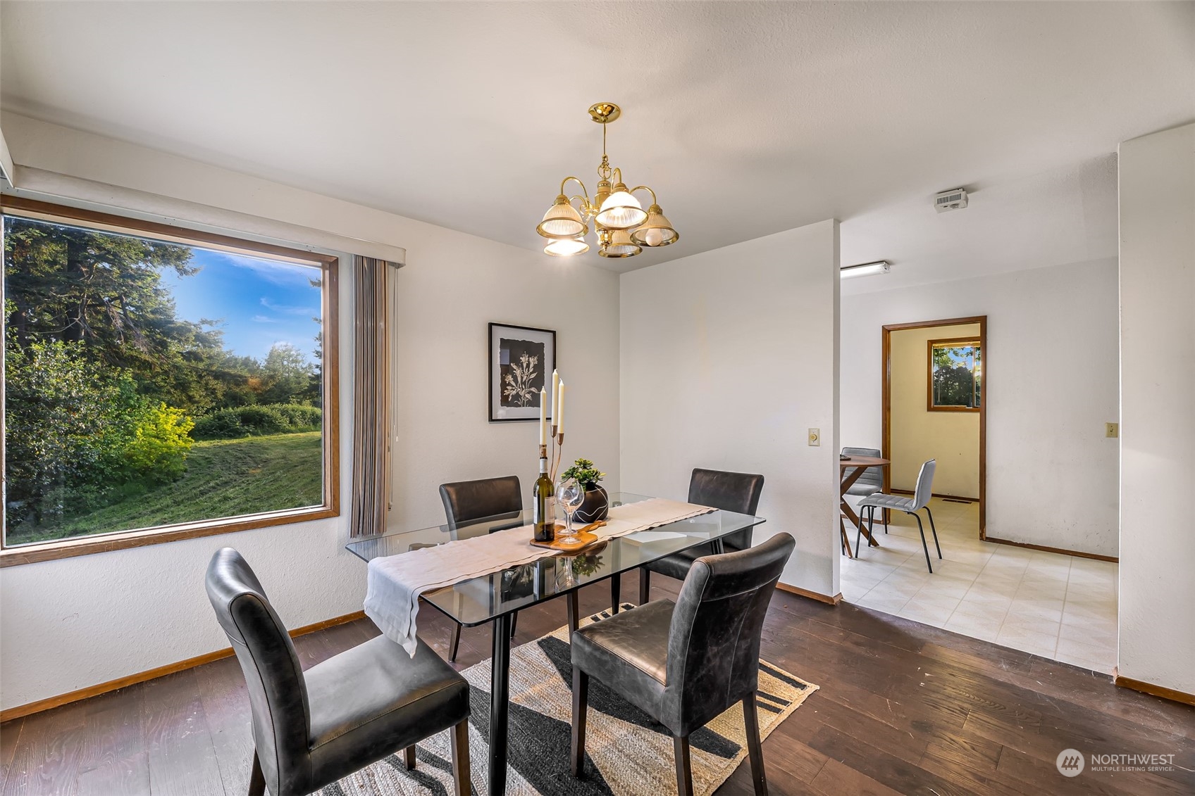 2835 Thornton Road Ferndale, WA 98248 - Photo 12 of 37 a dining room with wooden floor a chandelier a wooden table and chairs