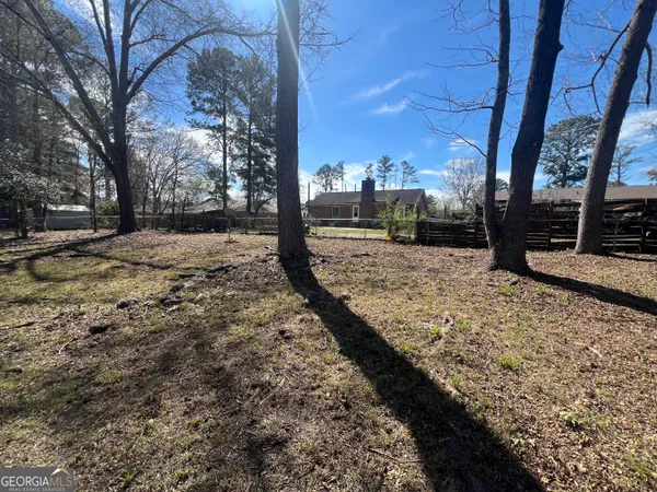 a view of a yard with wooden fence