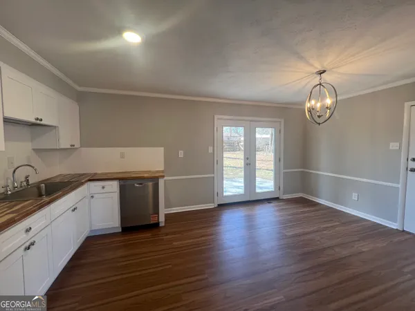 a kitchen with granite countertop a stove a sink and dishwasher with wooden floors