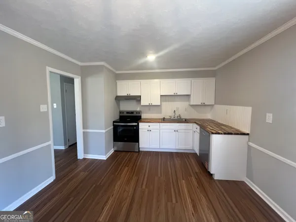 a kitchen with sink a refrigerator and a stove top oven