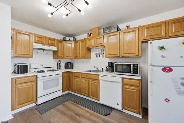a kitchen with granite countertop a sink stainless steel appliances and cabinets