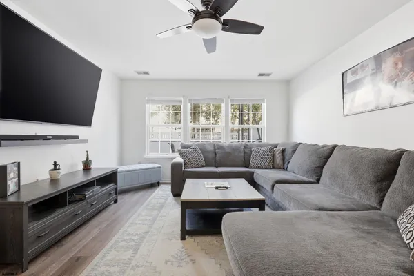 a living room with furniture flat screen tv and window