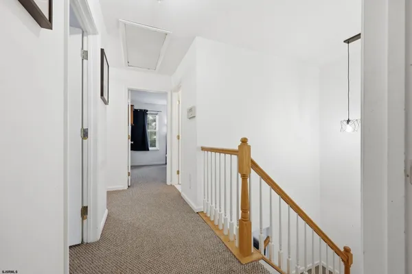a view of a hallway with wooden floor and entryway