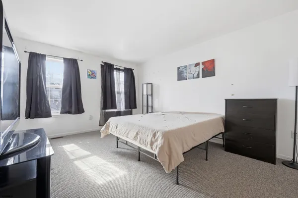 a spacious bedroom with a bed and a dresser
