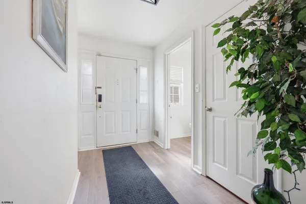 a view of a hallway with potted plants in front of door