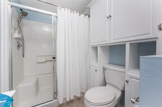 a white toilet sitting next to a shower