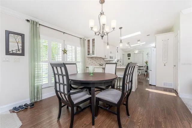 a view of a a dining room with furniture window and wooden floor