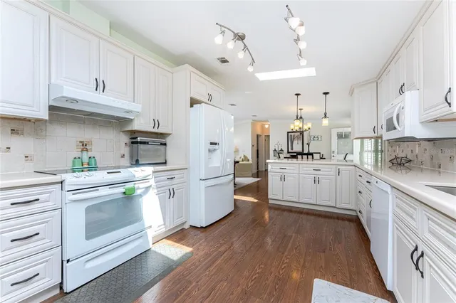 a kitchen with white cabinets and white appliances
