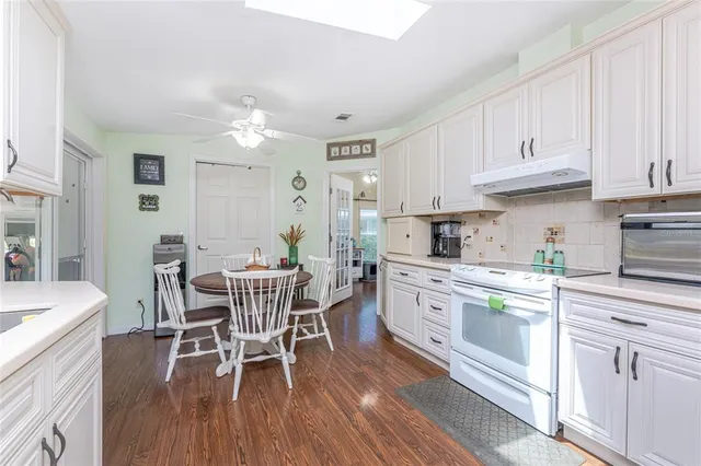 a kitchen with white cabinets stainless steel appliances and dining table