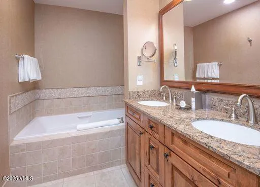 a bathroom with a granite countertop bathtub sink and mirror