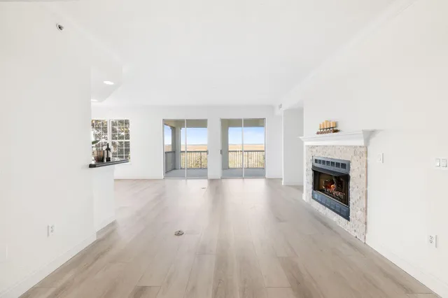 a view of a livingroom with wooden floor and a fireplace