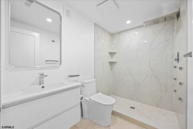 a view of a bedroom with wooden floor and a ceiling fan