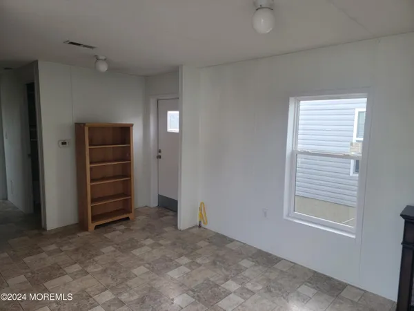 a view of an empty room with a cabinet and a window