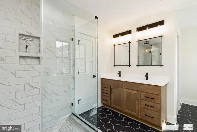 a bathroom with a double vanity sink mirror and shower