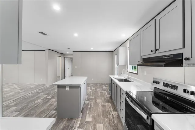 a kitchen with stainless steel appliances a stove a sink and a refrigerator