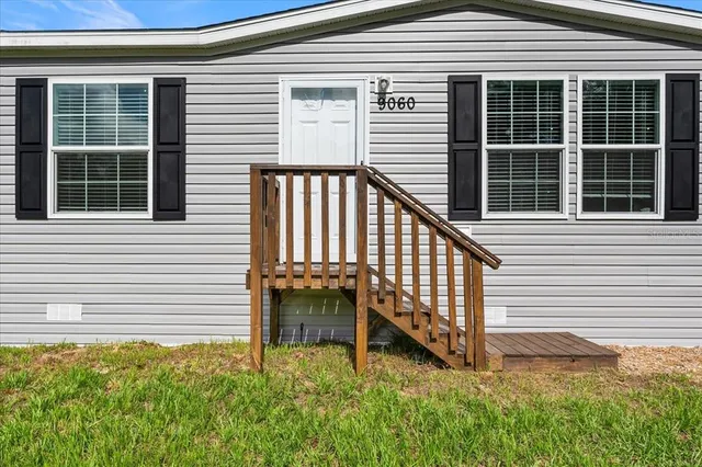a view of a house with a yard and sitting area