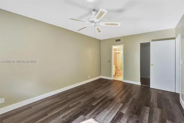 a view of a room with wooden floor and a ceiling fan