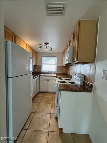 a kitchen with stainless steel appliances granite countertop a refrigerator sink and stove