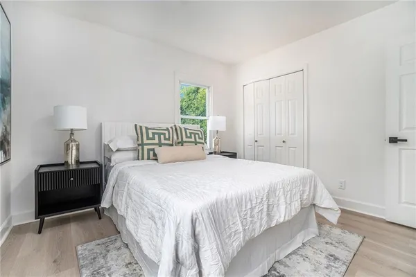 a bedroom with a bed and a lamp on desk