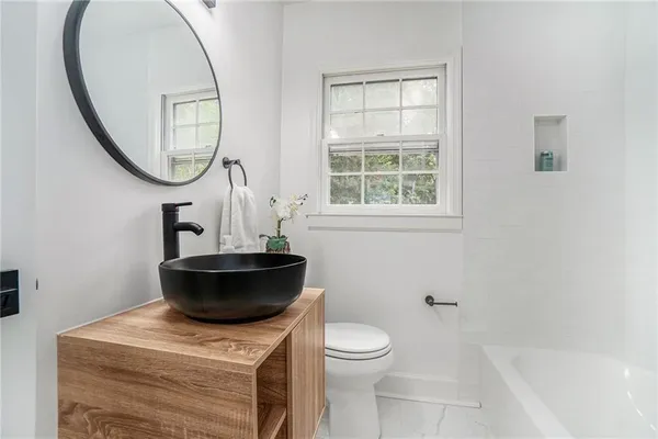 a bathroom with a toilet a sink and a mirror