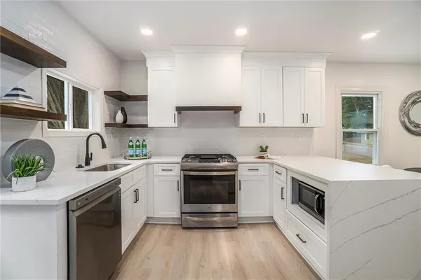 a kitchen with stainless steel appliances granite countertop a stove and a sink