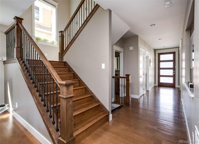 a view of staircase with lots of frames on wall and wooden floor