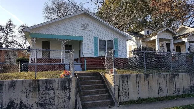 a view of a house with wooden stairs and a small yard