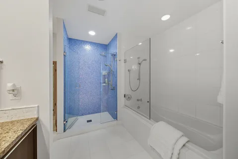 a en suite bathroom with a granite countertop sink and a mirror