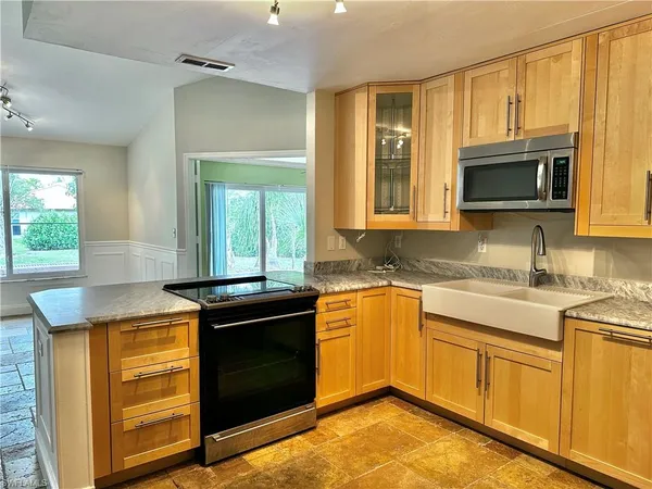 a kitchen with granite countertop cabinets stainless steel appliances and a window