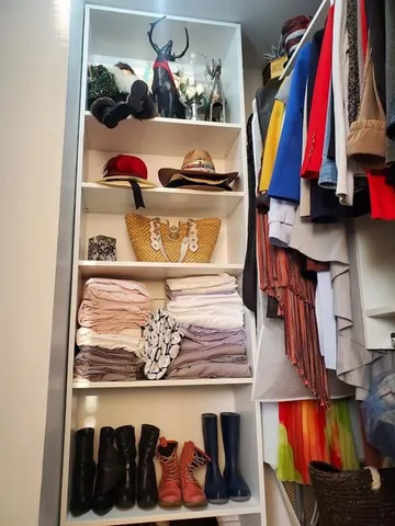 a view of walk in closet with clothes and shoes