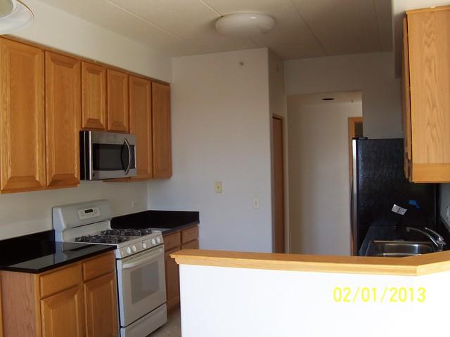 1731 Pavilion Way, Unit 408 Park Ridge, IL 60068 - Photo 6 of 16 a kitchen with stainless steel appliances granite countertop a refrigerator and a stove top oven
