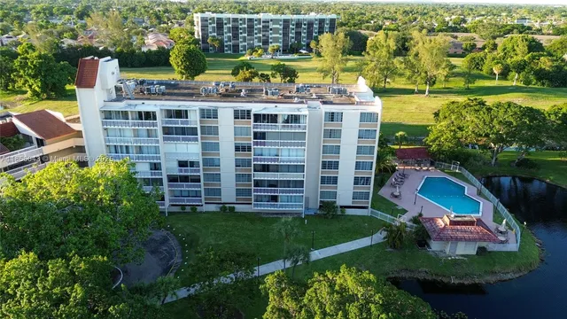 an aerial view of a house with a garden and lake view