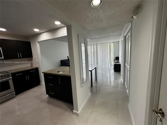 a kitchen with stainless steel appliances granite countertop a refrigerator and a stove top oven