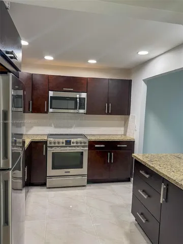 a kitchen with stainless steel appliances granite countertop a stove and a sink