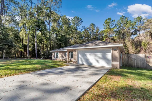 a view of a house with backyard and trees