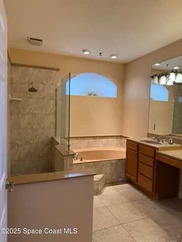 a bathroom with a tub a sink and mirror