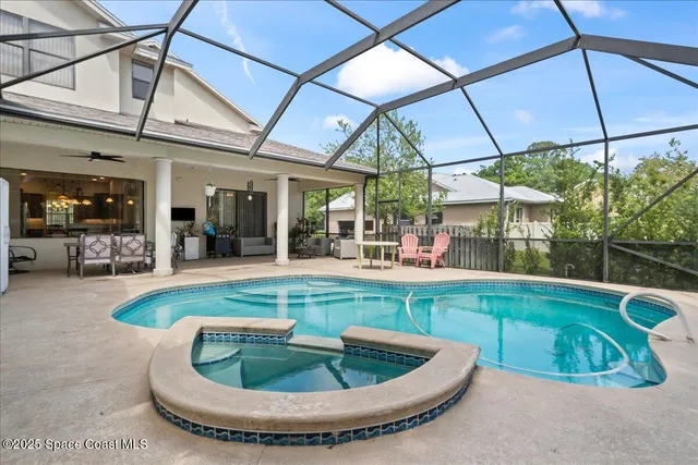 a view of a swimming pool with a dining table and chairs
