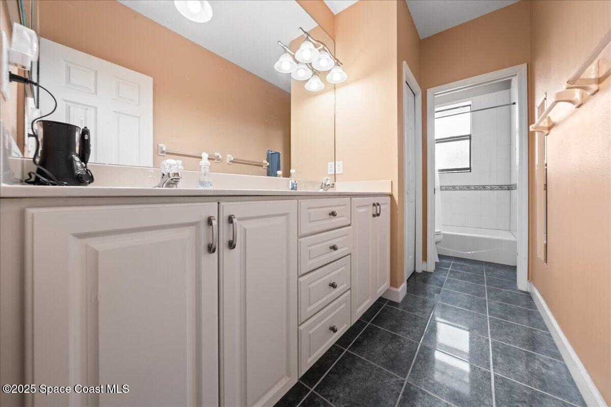 1777 Sienna Drive Melbourne, FL 32934 - Photo 21 of 31 a spacious bathroom with a double vanity sink a mirror and a shower