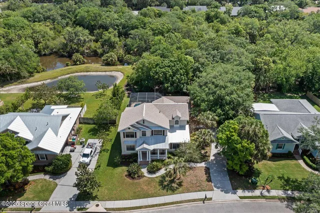 an aerial view of a house with a yard garage and lake view