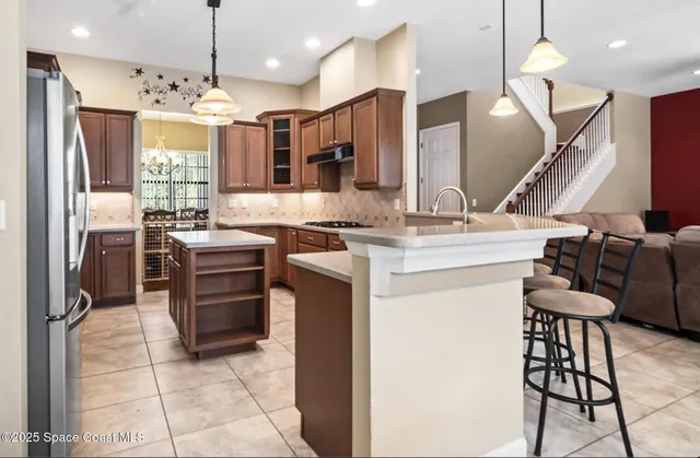 a kitchen with a sink appliances and wooden floor