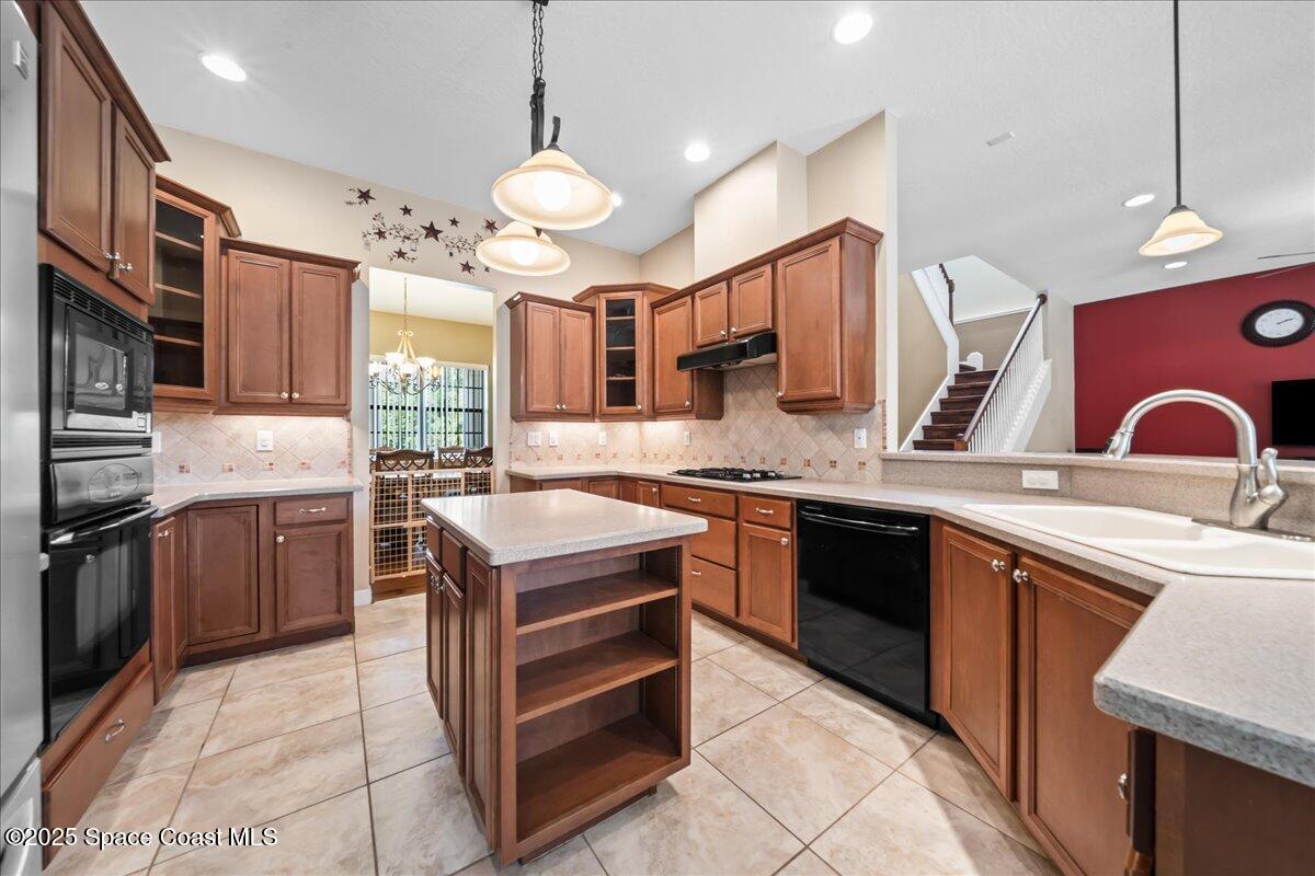 1777 Sienna Drive Melbourne, FL 32934 - Photo 8 of 31 a kitchen with stainless steel appliances granite countertop a stove a sink dishwasher and a microwave oven with white cabinets