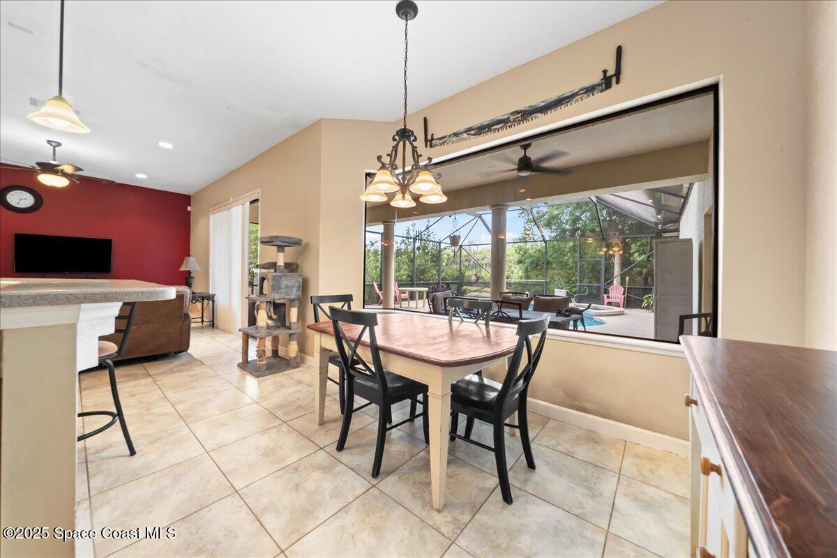 1777 Sienna Drive Melbourne, FL 32934 - Photo 9 of 31 a dining room with furniture a chandelier and fireplace