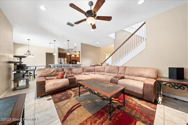 a living room with furniture and a view of kitchen