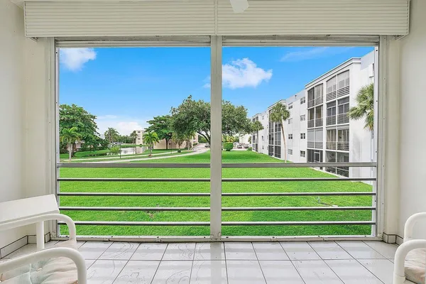 a green field with some trees in front of it