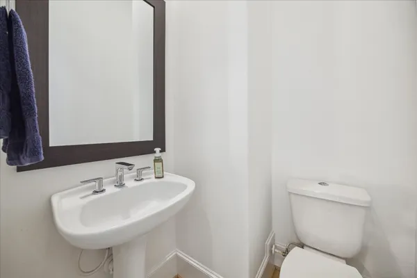 a bathroom with a sink a toilet and mirror