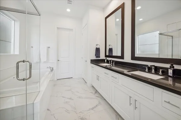 a bathroom with double vanity sinks and a mirror