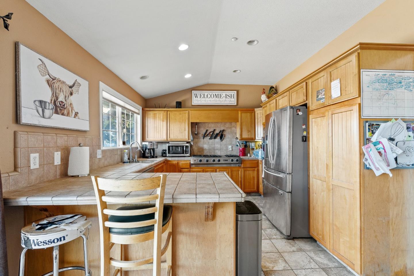 350 San Benancio Road Salinas, CA 93908 - Photo 20 of 68 a large kitchen with stainless steel appliances a stove a refrigerator a dining table and chairs with wooden floor