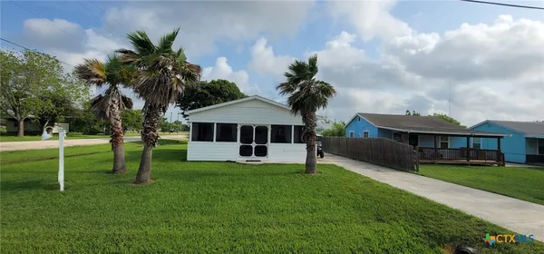 a view of a house with a big yard and potted plants