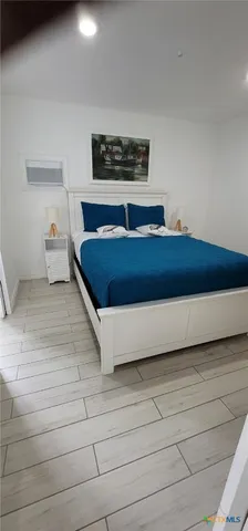 a bedroom with a bed and a night stand