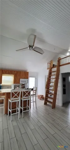 a view of a room with wooden floor furniture and windows